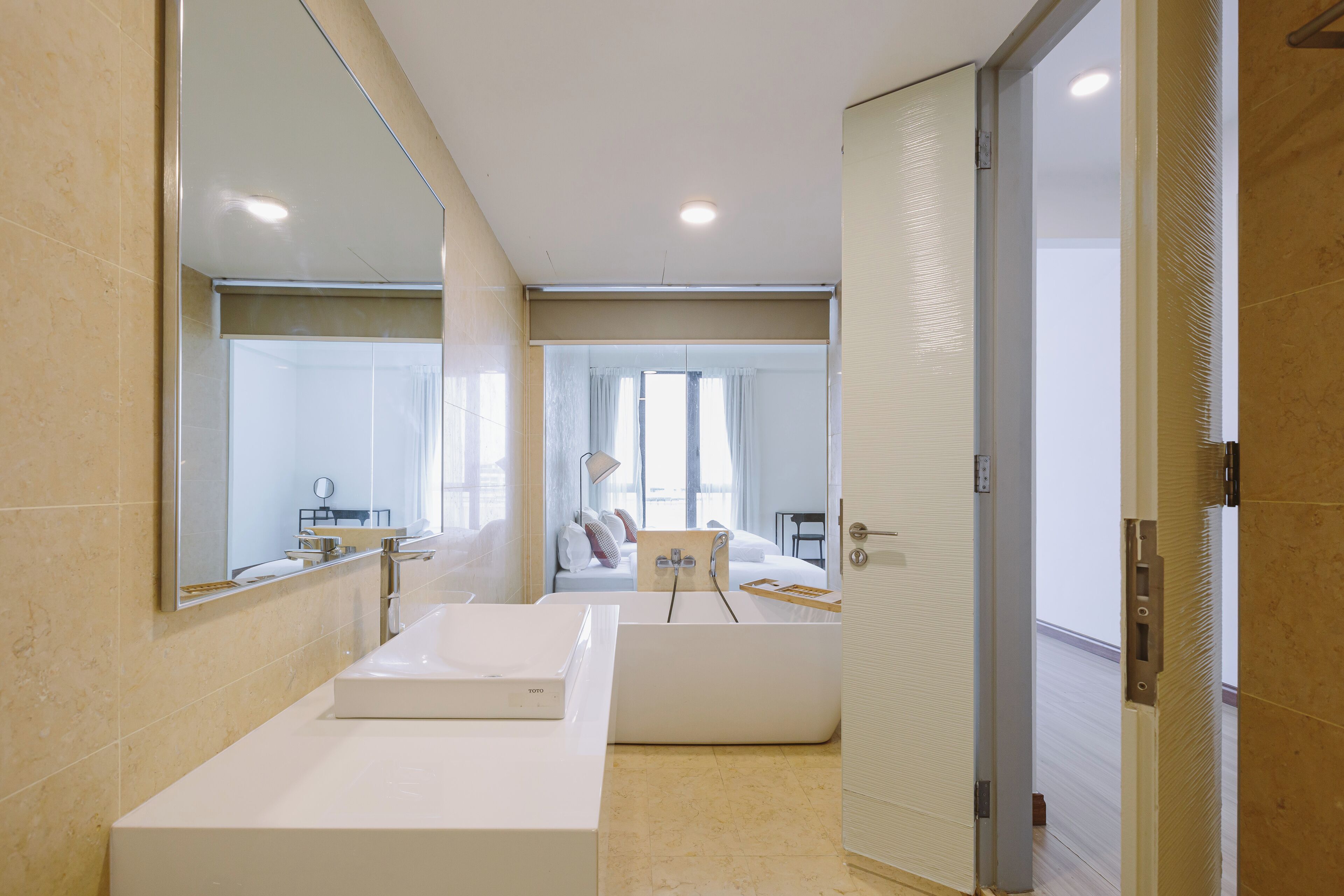 Un baño moderno con un espejo grande, un lavabo blanco y una bañera.