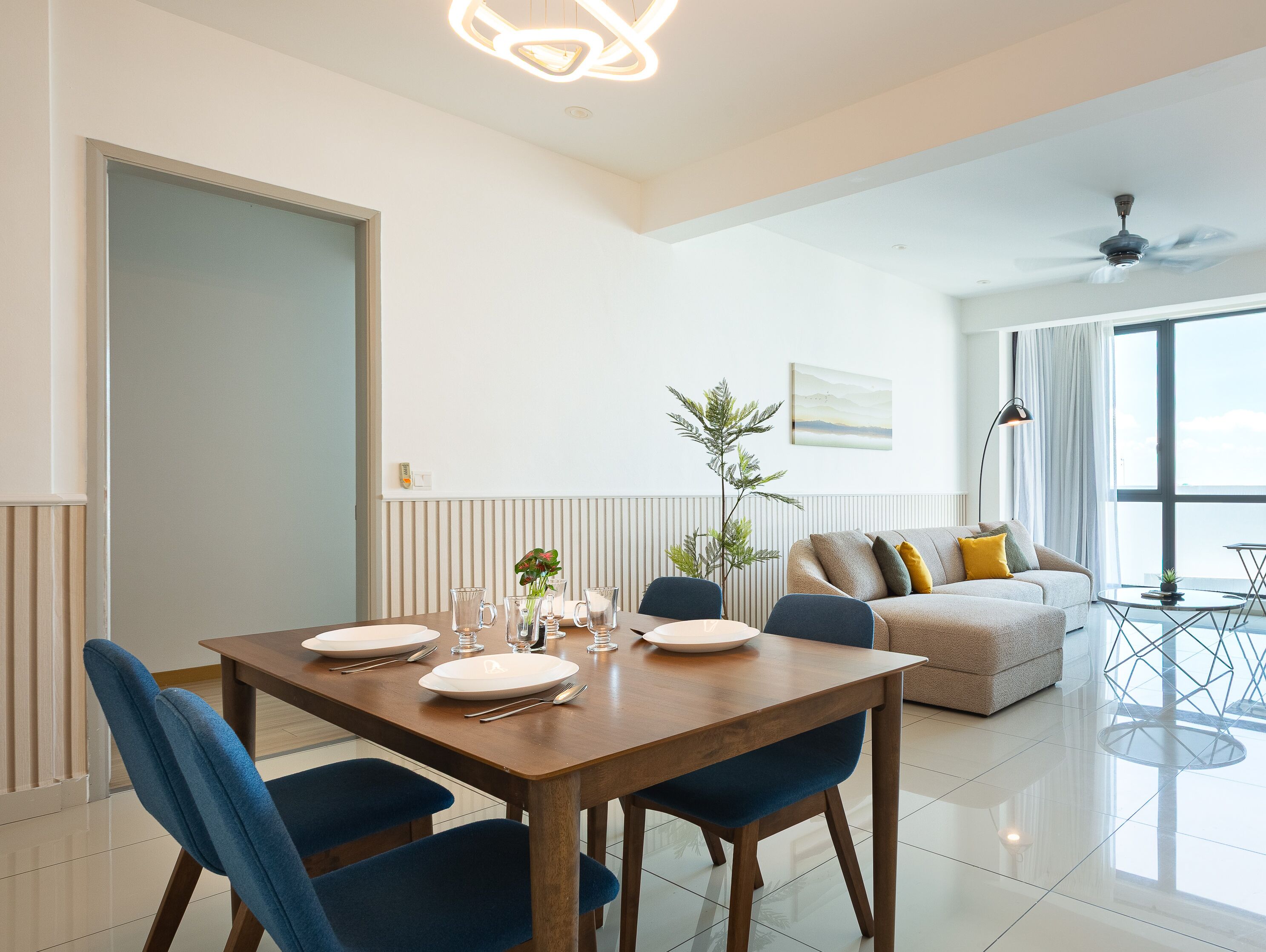Una sala moderna con comedor, un sofá y un ventilador de techo.