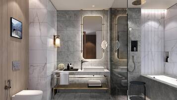 Un baño moderno con inodoro independiente, tocador con espejo, bañera y zona de ducha.