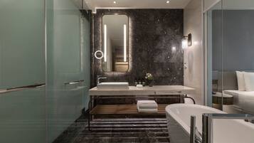 Ein modernes Badezimmer mit großem Spiegel, zwei Waschbecken, einer Badewanne und einer Duschkabine aus Glas.