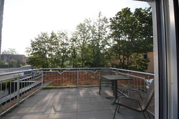 An outdoor balcony with a metal railing, a table, and two chairs. - Moderne Ferienwohnung in Ruhiger und Zentraler Lage von Prenzlau (Prenzlau)