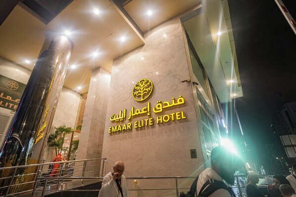 Exterior del hotel Emaar Elite, con un llamativo letrero y un diseño arquitectónico moderno.