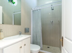 A bathroom with a white sink, toilet, and shower area. - Mallom at Dalebrook tidal pool (Cape Town)