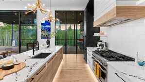 Una cocina moderna con una isla grande, estufa y vistas a la vegetación.