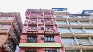A multi-story building with balconies and large windows.