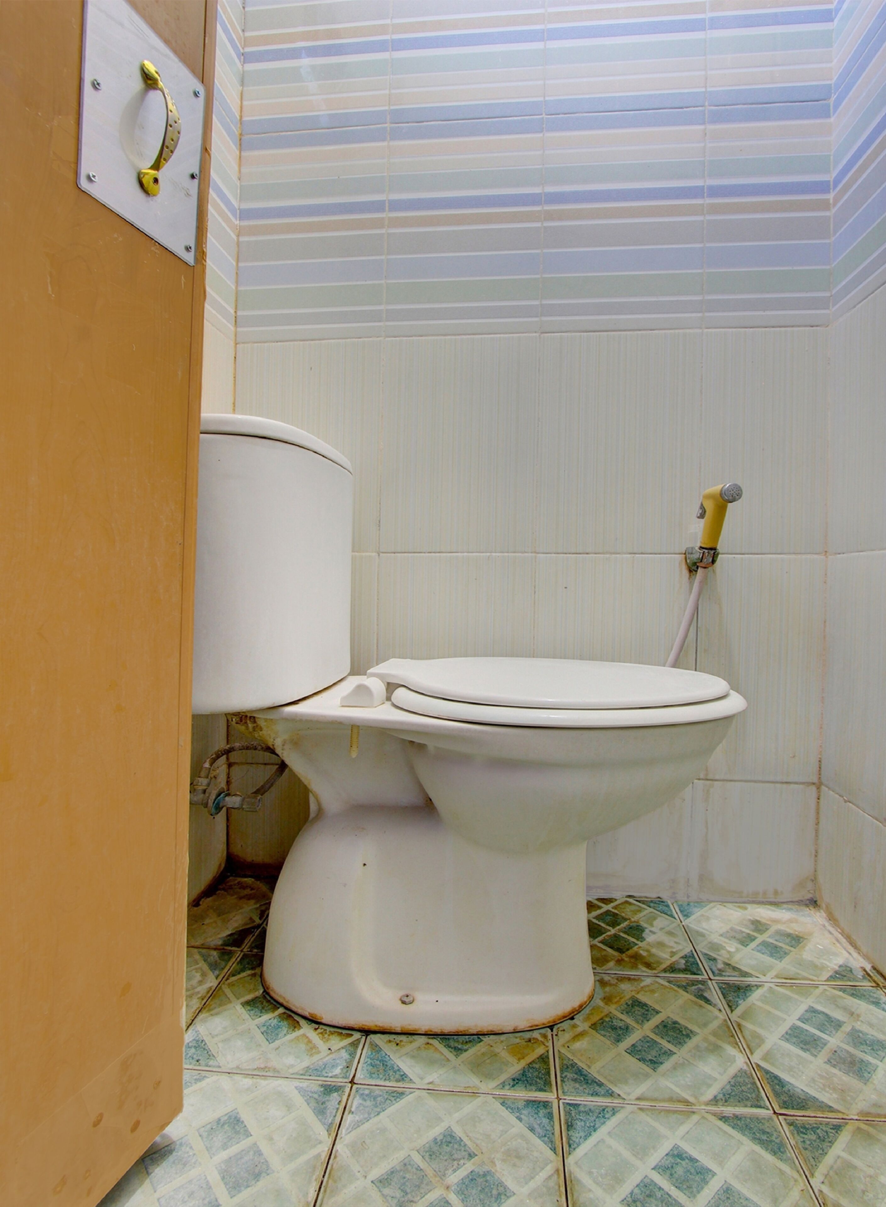 A toilet with a tank, a flush handle, and a pipe.