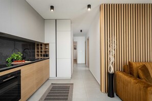Enjoy a stylish living space with sleek cabinetry, an oven, and a comfortable sofa.