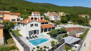 A residential area with a swimming pool, tennis court, and hillside views. - Mediterranean villa Anatai with a sea view (Drenje)