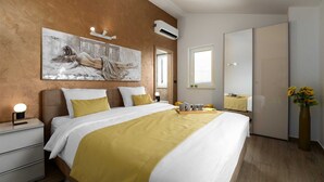 A modern bedroom with a large bed, a painting, an air conditioning unit, and a mirror. - Mediterranean villa Anatai with a sea view (Drenje)
