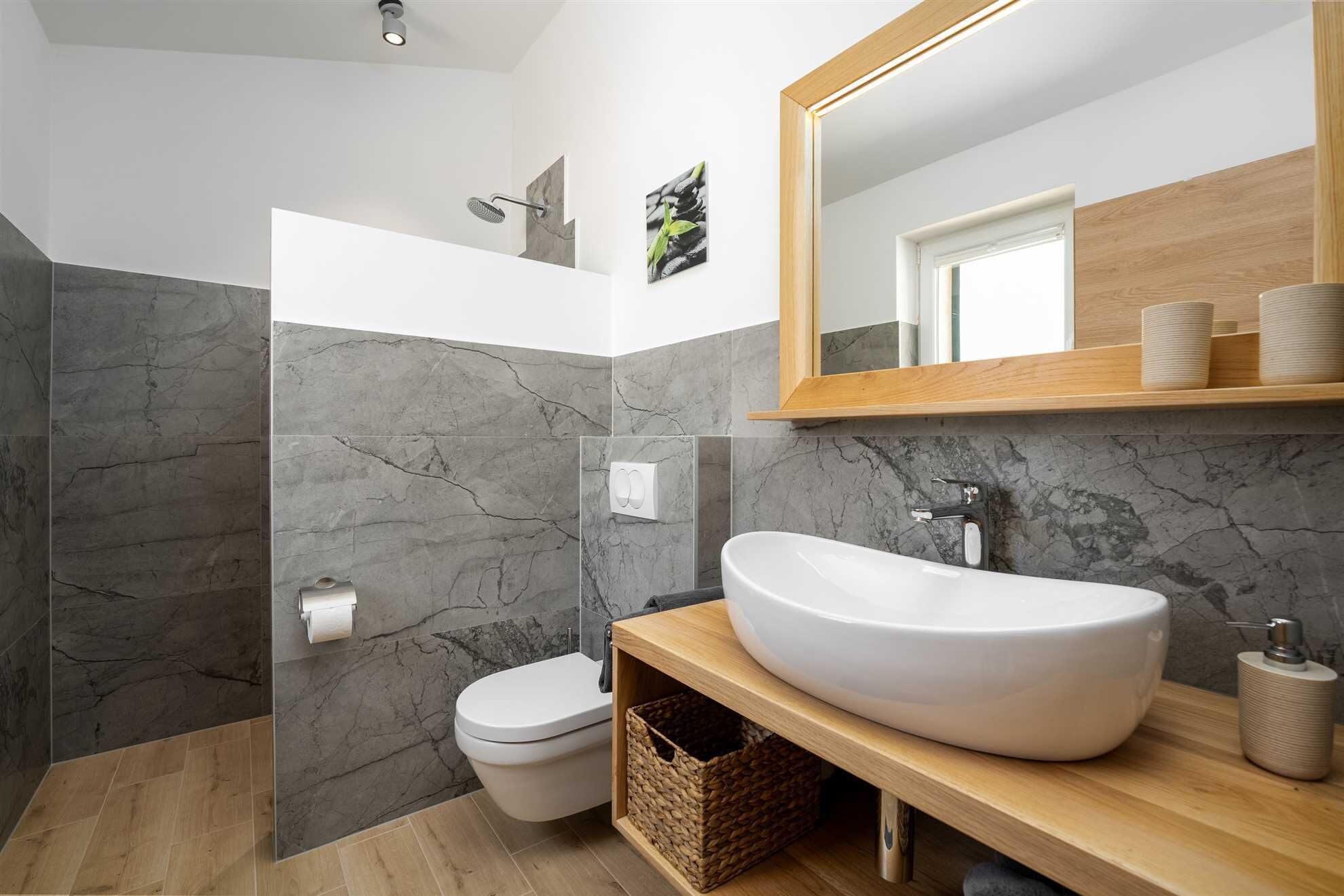 A modern bathroom with a freestanding bathtub, a large mirror, and a shower area.