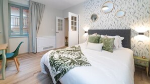 Een slaapkamer met een bed, een bureau en een stoel.