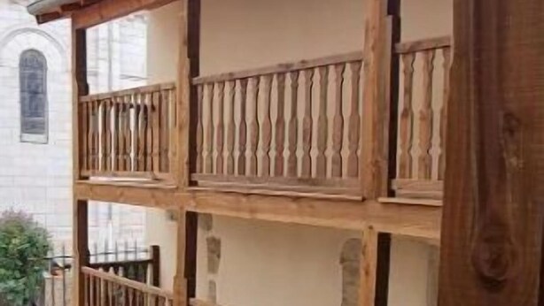 Een meerlaags houten balkon met een trap naar een zitgedeelte buiten.