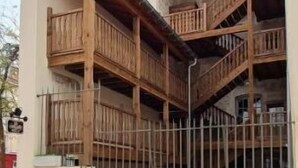 Een gebouw met een houten balkon en een hekwerk.