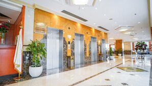 A hotel lobby with a reception desk, elevators, and a marble floor. - EMMAR AL NOOR (Makkah)