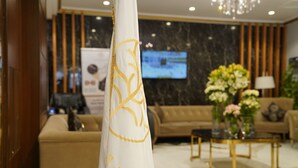 A reception area with a white pillar, a television screen, a sofa, and a coffee table. - Emaar Andalusia (Makkah)
