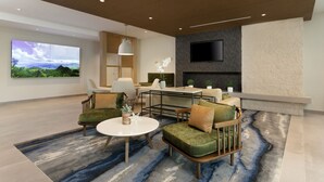 Una sala de estar moderna con televisor de pantalla plana, chimenea y un ventanal con vista al paisaje.