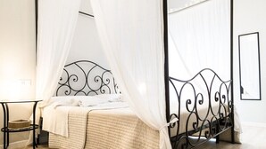 Un lit avec une tête de lit en métal, une table de chevet et un panier suspendu.