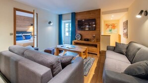 A modern living room with a sofa set, a coffee table, and a TV mounted on the wall. - APPALACHES, Annecy Rent Lodge (Annecy)