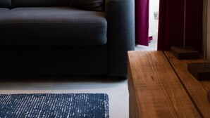 A modern living room with a grey sofa, a wooden coffee table, and a painting of a mountain landscape on the wall. - CAUCASE, Annecy Rent Lodge (Annecy)