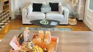 A modern living room with a white sofa, a coffee table, and a wicker pendant light. - COSY HOME, Annecy Rent Lodge (Annecy)