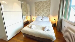A bedroom with a large bed, a wardrobe, a radiator, and a window. - COSY HOME, Annecy Rent Lodge (Annecy)