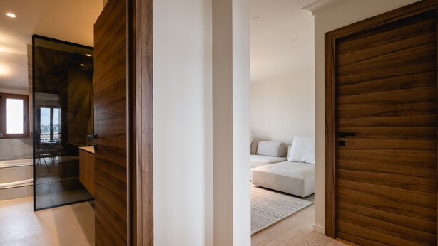 Un interior moderno con paneles de madera, un sofá y vistas a través de un ventanal.
