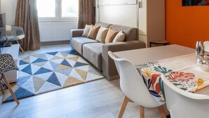 Una sala de estar moderna con un sofá, una mesa de comedor y un mueble grande.