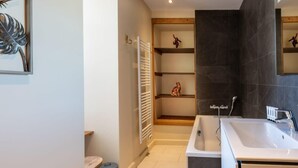 A modern bathroom with a bathtub, a sink, and a shower. There is a towel rack and a small trash bin. - APPENNINS, Annecy Rent Lodge (Annecy)