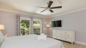 A bedroom with a bed, a ceiling fan, a dresser, and a window with curtains. - 23 Willow Oak West: Sea Pines Home, 4BR, Pool, Hot Tub, Free Bikes (Hilton Head Island)