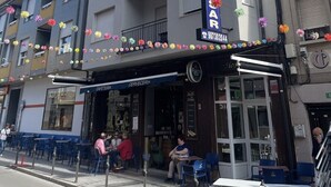 Un hotel llamado "Hostal Julio Cesar" con una fachada moderna, balcones y un café en la planta baja.
