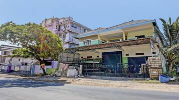 A two-story building with a balcony and a covered entrance.