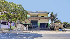A two-story building with a blue door and a balcony. - OYO Life 93037 Nova Jaya Homestay Syariah  (Jogoroto)