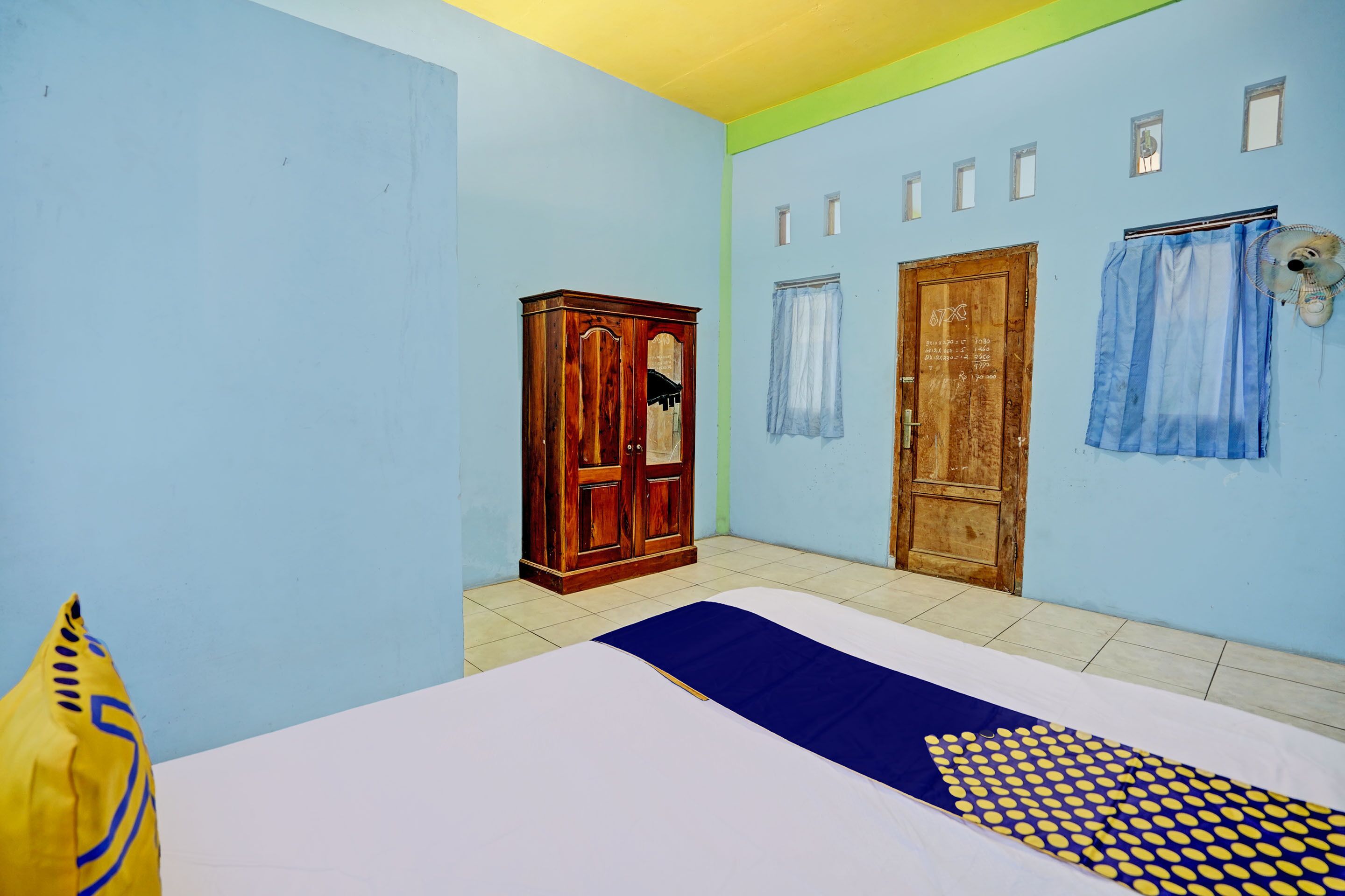A room with a bed, a wardrobe, and two doors.