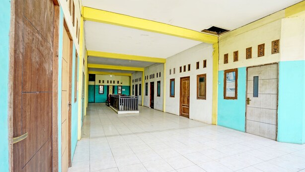 A spacious hallway with tiled floors and doors on both sides. - OYO Life 93037 Nova Jaya Homestay Syariah  (Jogoroto)
