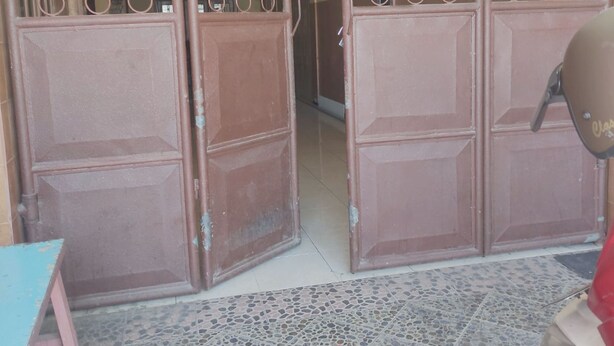 A gated entrance with a sign indicating a room number and a name.