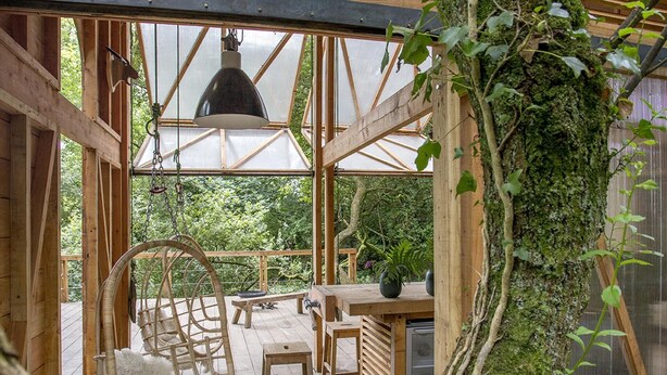 A wooden interior with a large glass window, a hanging light fixture, and a rustic dining area. - 6 Person Cabin, Surrounded by Nature in Tintagel (Tintagel)