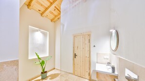 A bathroom with a wooden door, a potted plant, and a mirror. - Nouba Villas (Kas)