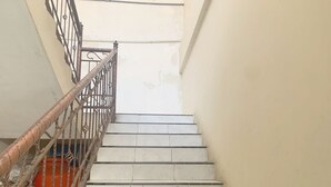 A staircase with white tiles and a metal railing.