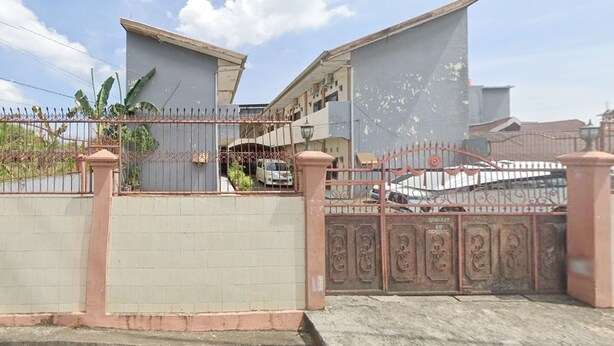 A gated residential area with a white car parked inside.