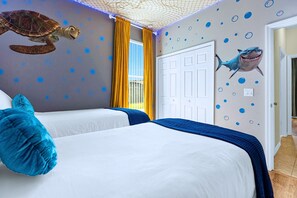 A room with two beds, a turtle mural, a shark mural, and a netted ceiling. - Upstay: Crystal Cove Resort Villa w/ Pool & Games (Kissimmee)