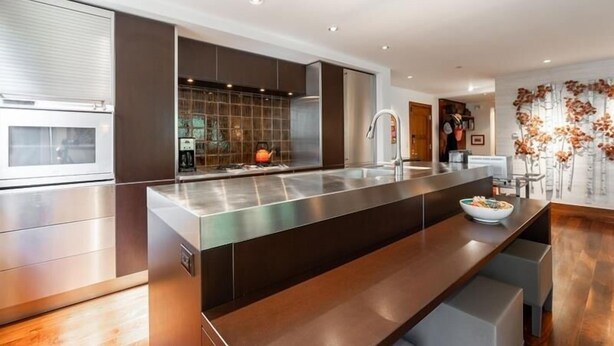 A modern kitchen with a large island, stainless steel appliances, and a built-in oven. - Riverhouse #3 2 Bedroom Condo by RedAwning (Vail)