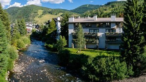A hotel with a river view, surrounded by greenery and mountains. - Riverhouse #3 2 Bedroom Condo by RedAwning (Vail)