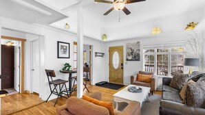 A spacious living room with a ceiling fan, a dining area with a table and chairs, and a cozy seating area with a sofa and armchairs. - Main Level Haven | Steps from the Hot springs | Sleeps 9 (Ouray)