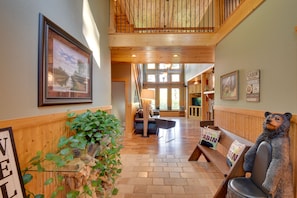 A wooden interior with a bench, a bear statue, and a framed picture on the wall. - Expansive Mtn-View Ellijay Cabin: Private Hot Tub (Ellijay)
