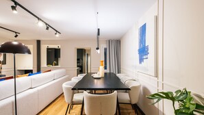 A modern dining area with a black table, white chairs, and a large plant. - Grand 200m² Luxury Residence, 4 En-Suites, Patio, Gran Vía area Quiet, A/C (Madrid)