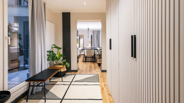 A modern hallway with a bench, potted plants, and a view into a dining area. - Grand 200m² Luxury Residence, 4 En-Suites, Patio, Gran Vía area Quiet, A/C (Madrid)