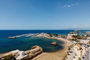 A coastal town with a marina, sandy beach, and clear blue sea.