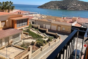 Ein Küstenwohngebiet mit Reihenhäusern, freiem Blick auf das Meer und einem Stoppschild im Vordergrund.