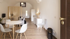A modern hotel room with a dining area, a kitchen, and a living space. - Domus 47 Pompei (Pompei)