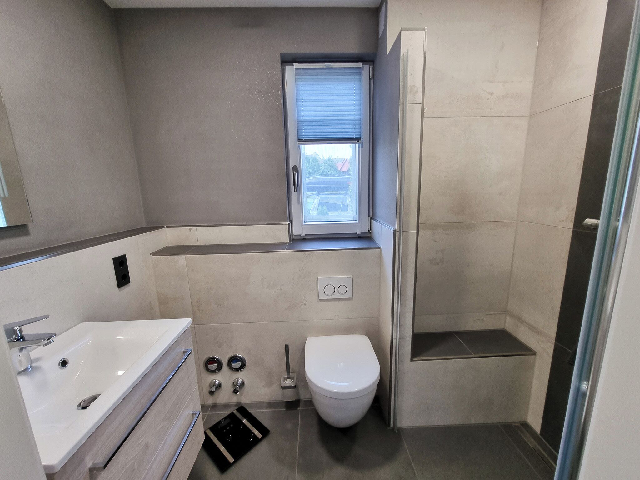 A bathroom with a bathtub, toilet, and window.